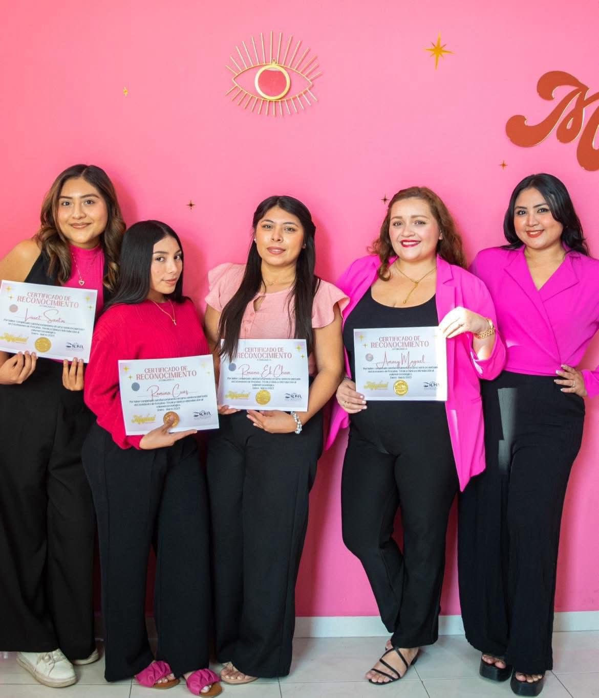 Alumnas graduadas con su certificado de reconocimiento